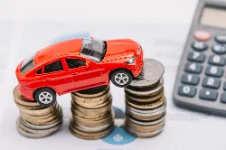 Toy car sitting on stack of coins