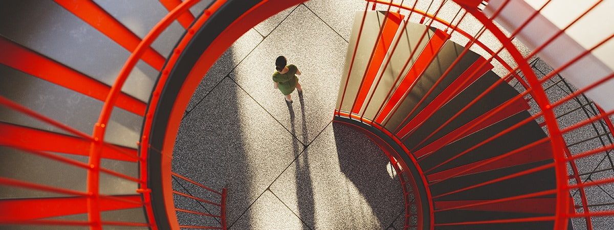 top-down view of a person walking up a vibrant red spiral staircase, casting a long shadow on the ground.