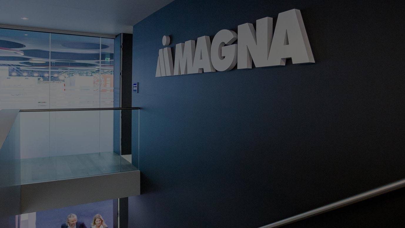 Magna logo against navy blue wall 