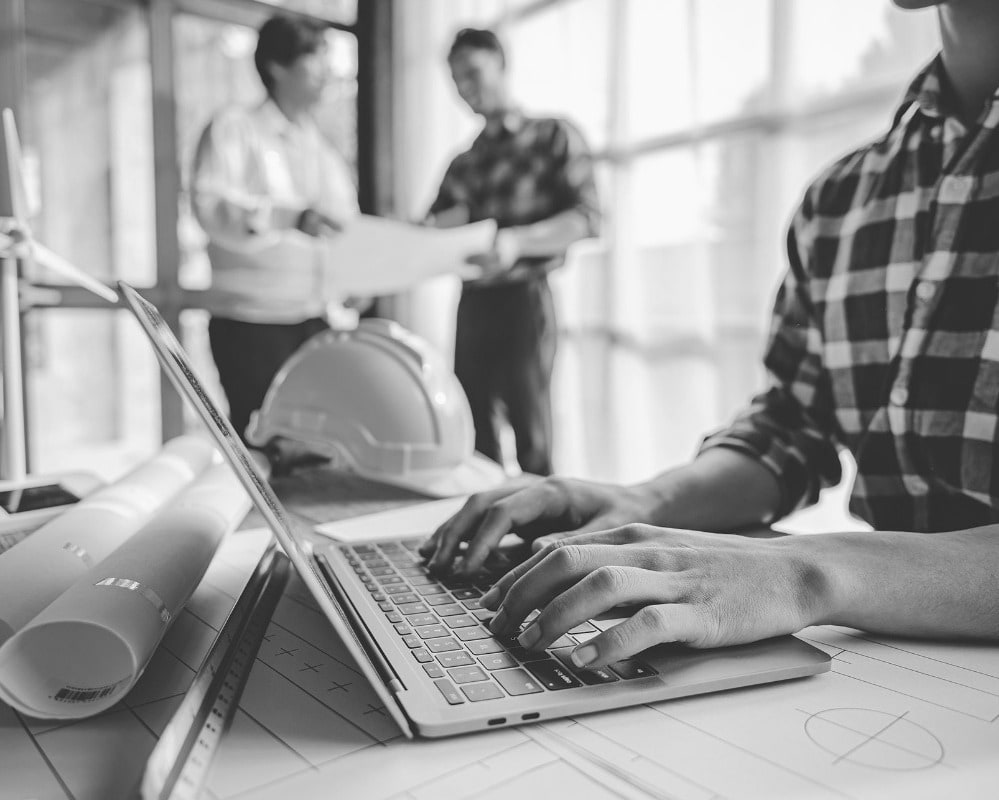 Construction office - man typing on laptop