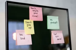 Colorful sticky notes on a mirror, illustrating the concept of goal-setting and prioritising.