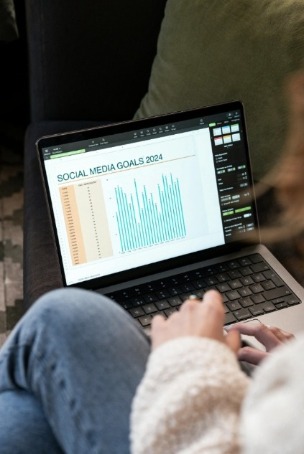 Viewing social media goals chart on laptop 