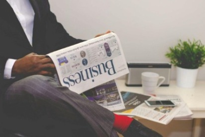 Individual reading a business newspaper