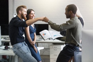 Co workers fist bumping and smiling