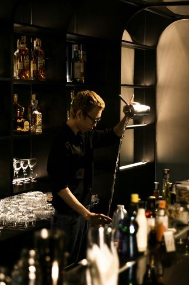 A person pouring a drink into a bar  AI-generated content may be incorrect.