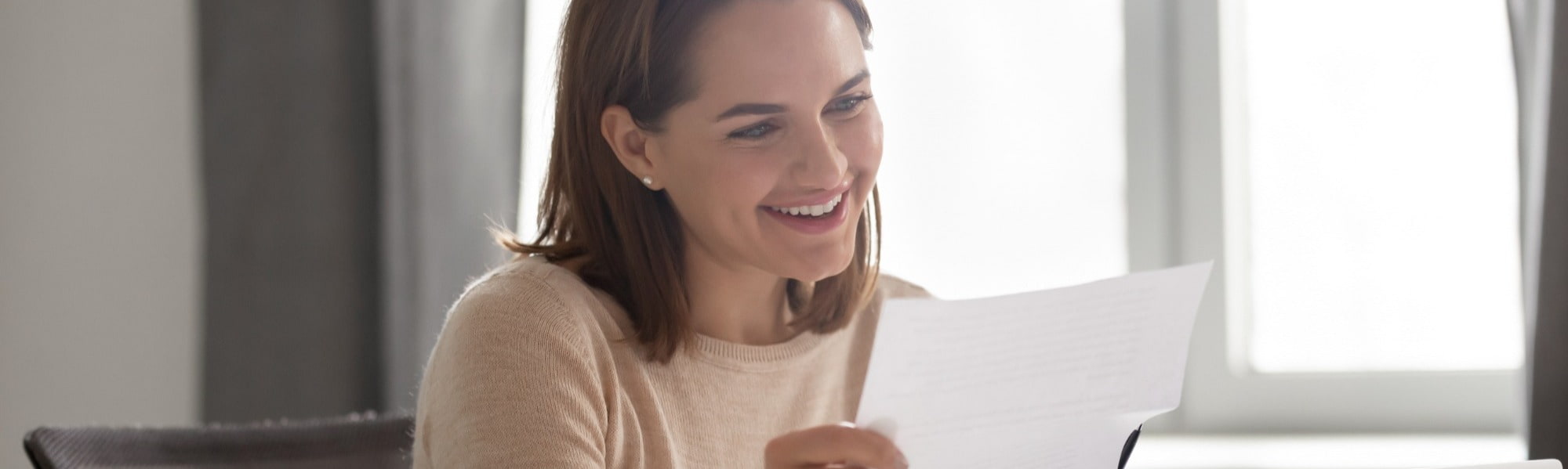 Happy young businesswoman reading cover letter for job interview