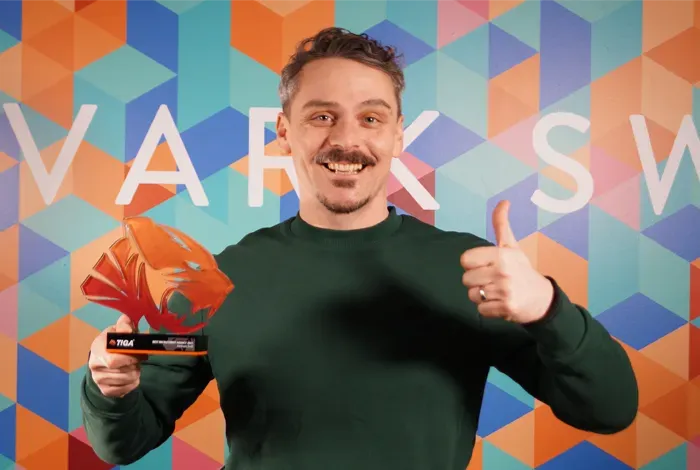 Picture of Programming Team Lead Dave Moss holding the 2021 TIGA Award