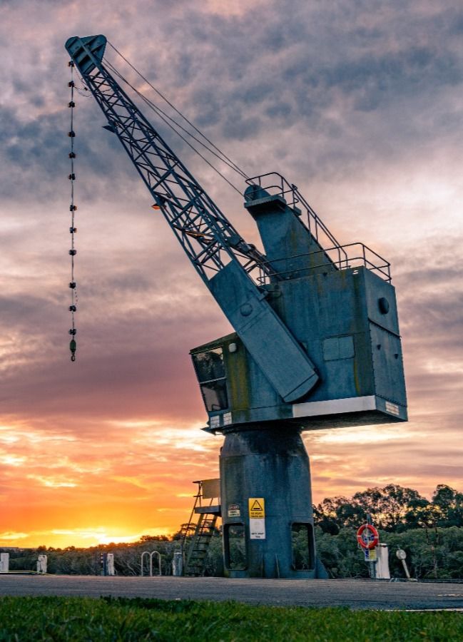 image of a large crane with a sunset background