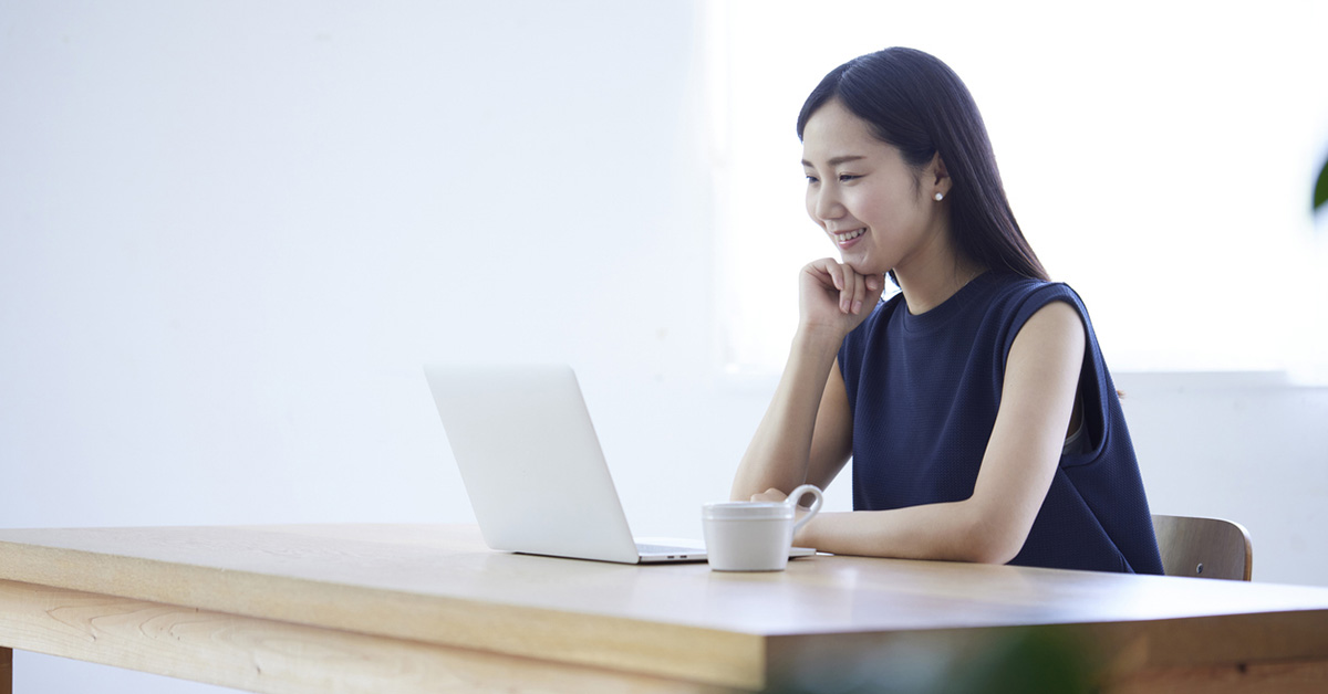 自宅でノートパソコンを使って英語を勉強している日本人女性