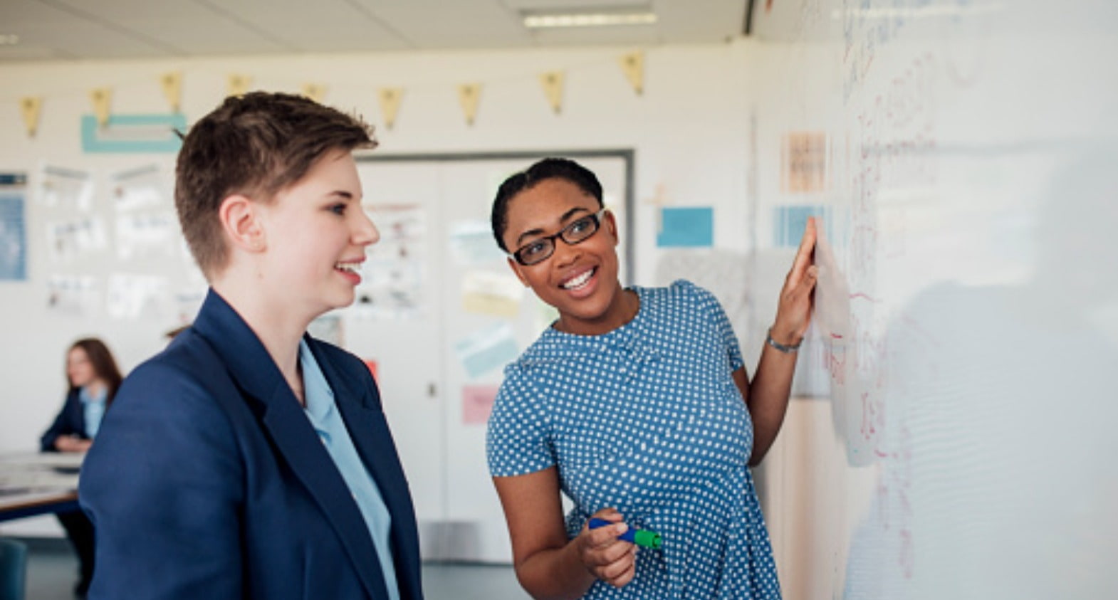 Jamaican teacher with her student at the whiteboard