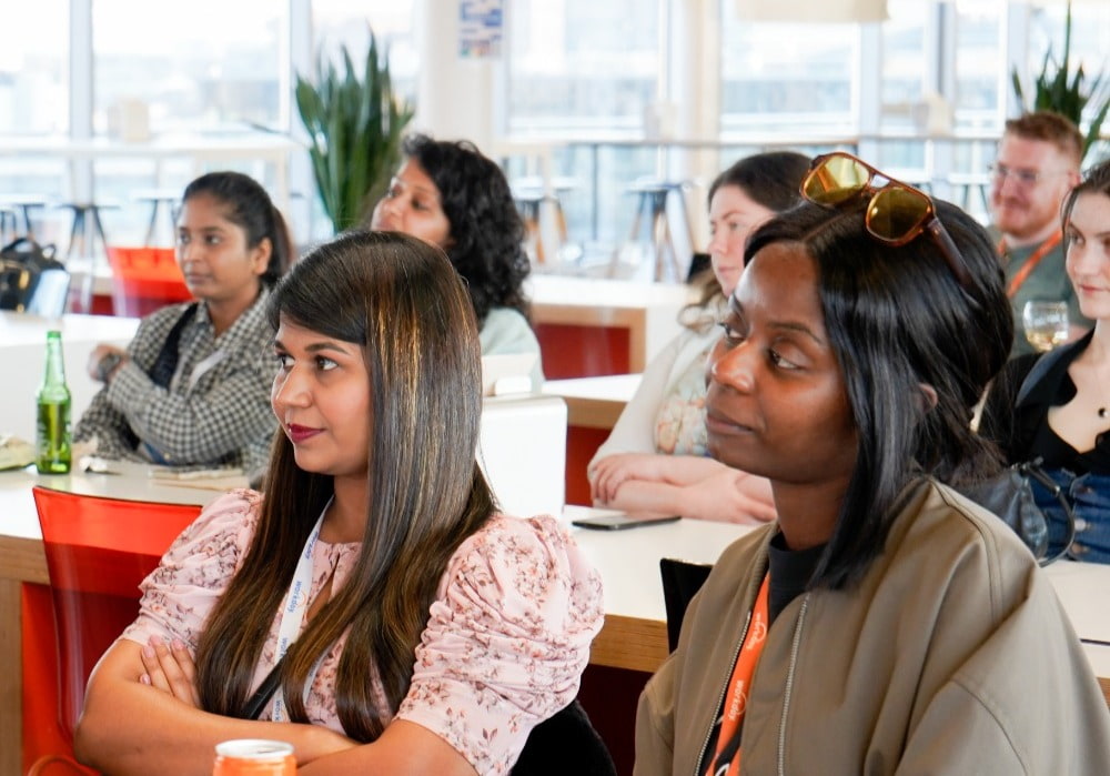 Seven people in an office listening at a community event