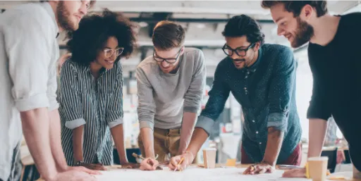 Team of people around a table discussing papers