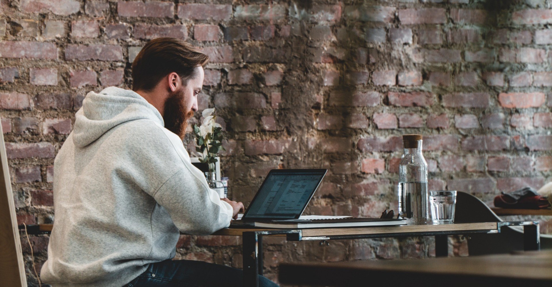 Man sat working on this laptop in a cafe environment