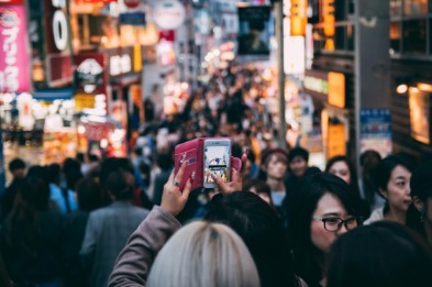 : phone being held up in a street in Japan 