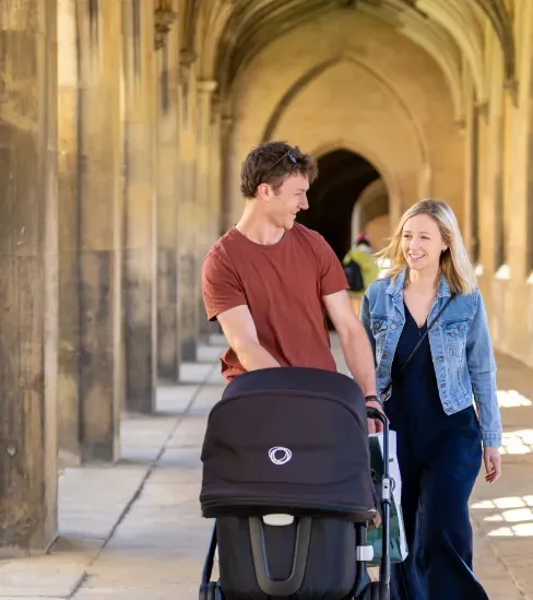 Couple walk with pram through New Court