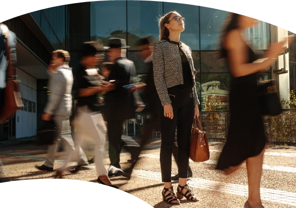 Woman on a busy street looking up at the sky