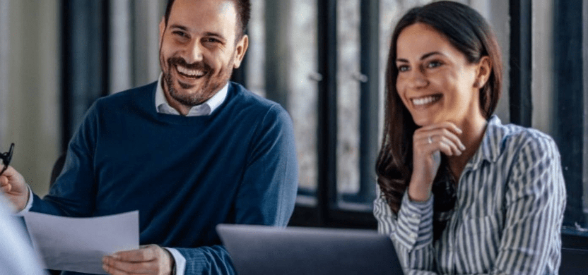 Man and woman smiling with laptop