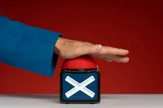 A hand grips a box featuring a red and blue cross, representing a message of rejection.