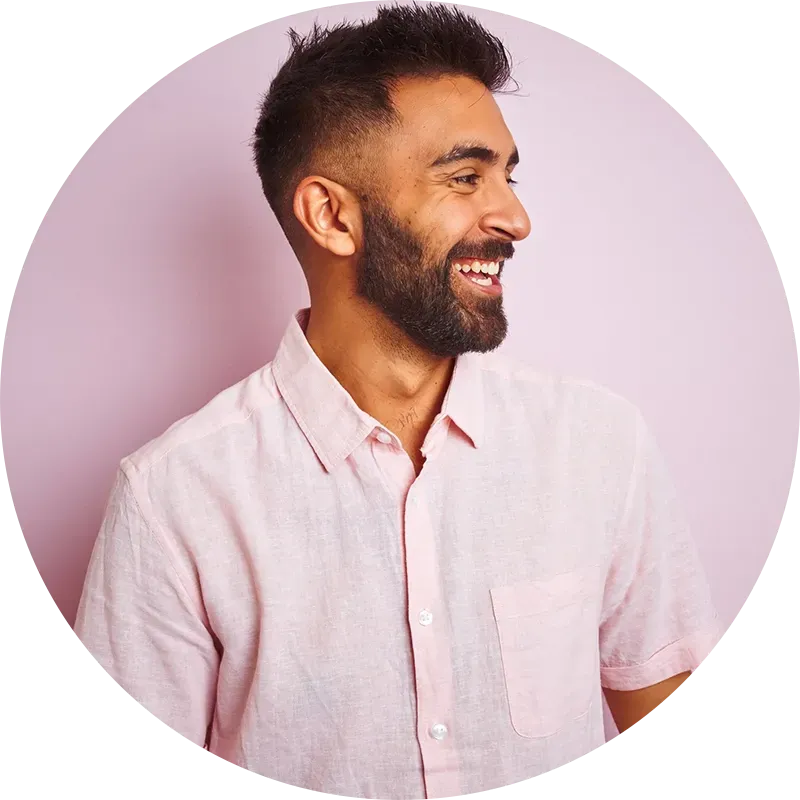 Bearded man laughing with a pink background