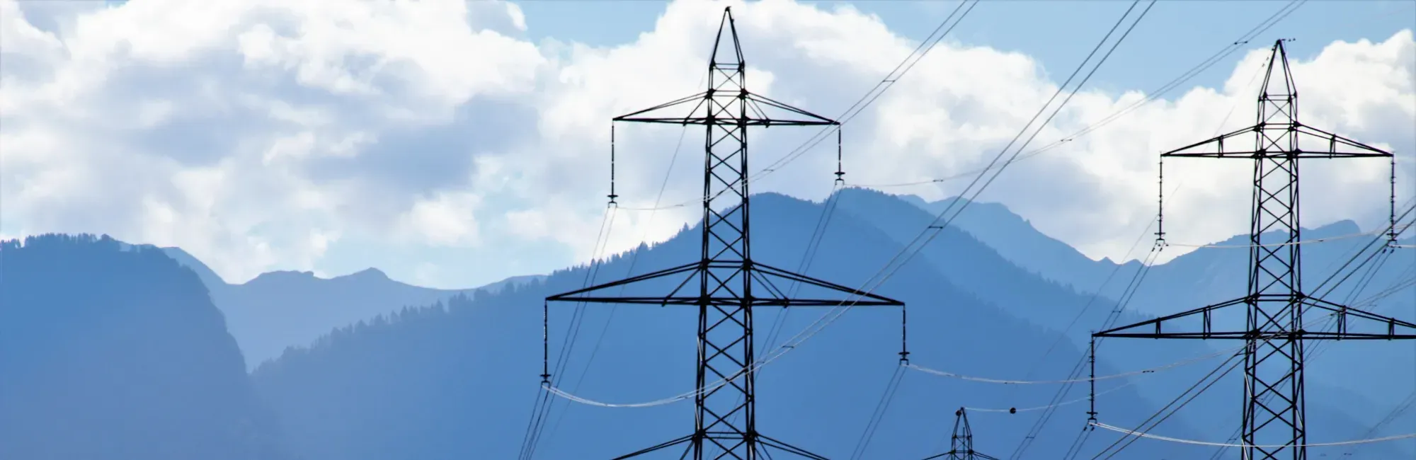 Energy pylons in front of misty mountains