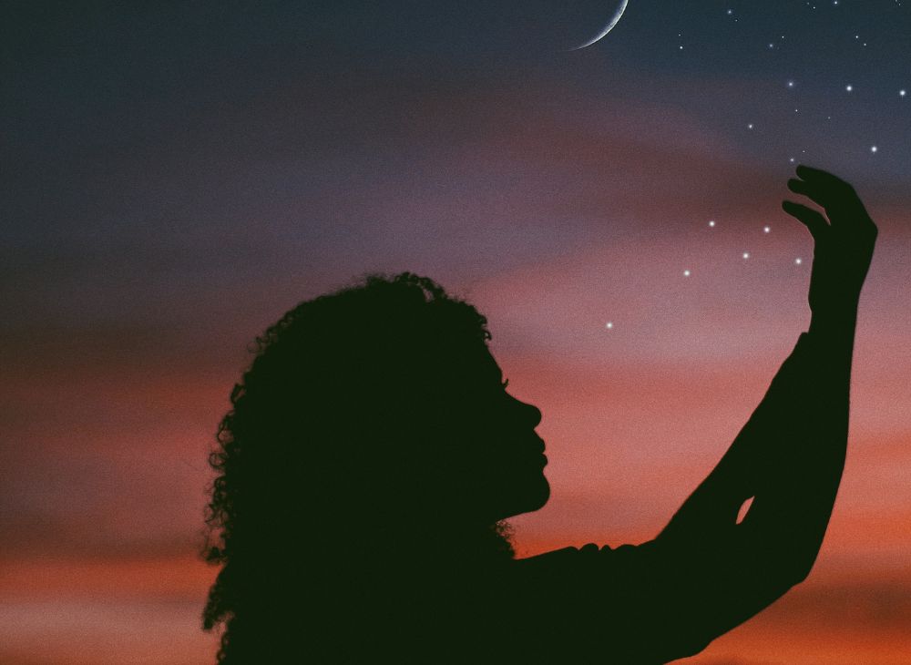 sillhouette of a woman with pink night sky