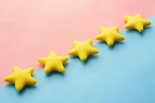 A colorful background of blue and pink featuring five yellow stars, representing constructive feedback and encouragement.