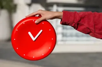 A hand gripping a red clock, illustrating the concept of temporary work.
