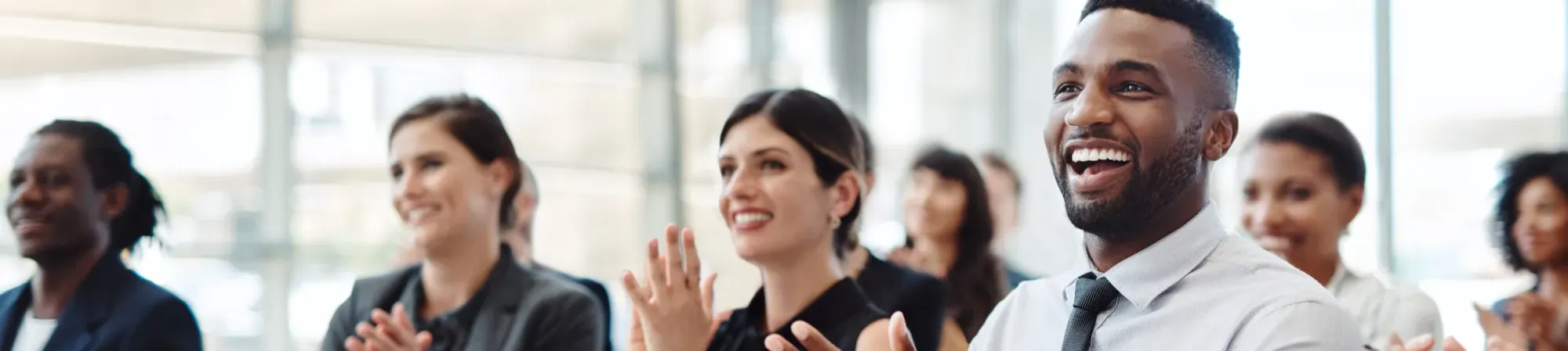 A banner image of people applauding in a meeting