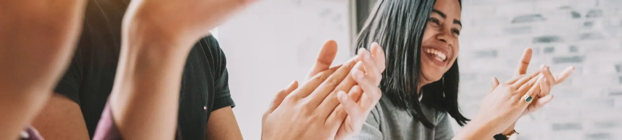 A banner image of people applauding in a meeting