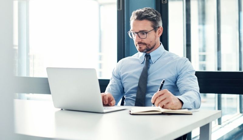 Professional business man making notes from his laptop