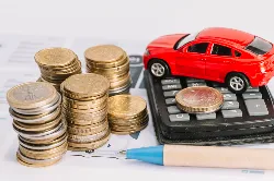 Toy car, surrounded with a calculator and coins