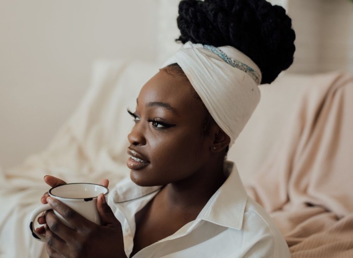 Woman holding hot drink and reflecting