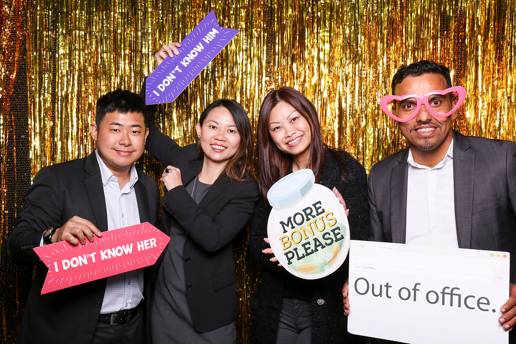 Photobooth photo with two men and two women holding signs