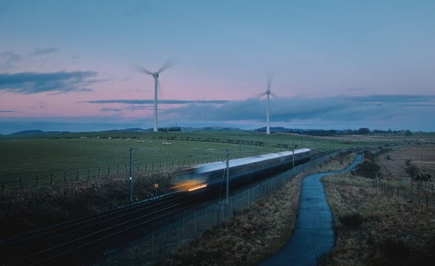 Train running through windmill farm 