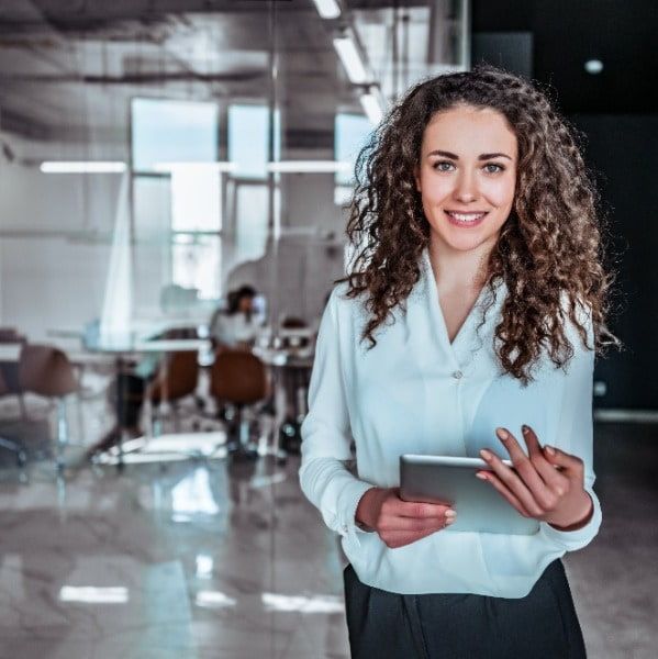 Waist up portrait modern business woman in the office attire holding tablet