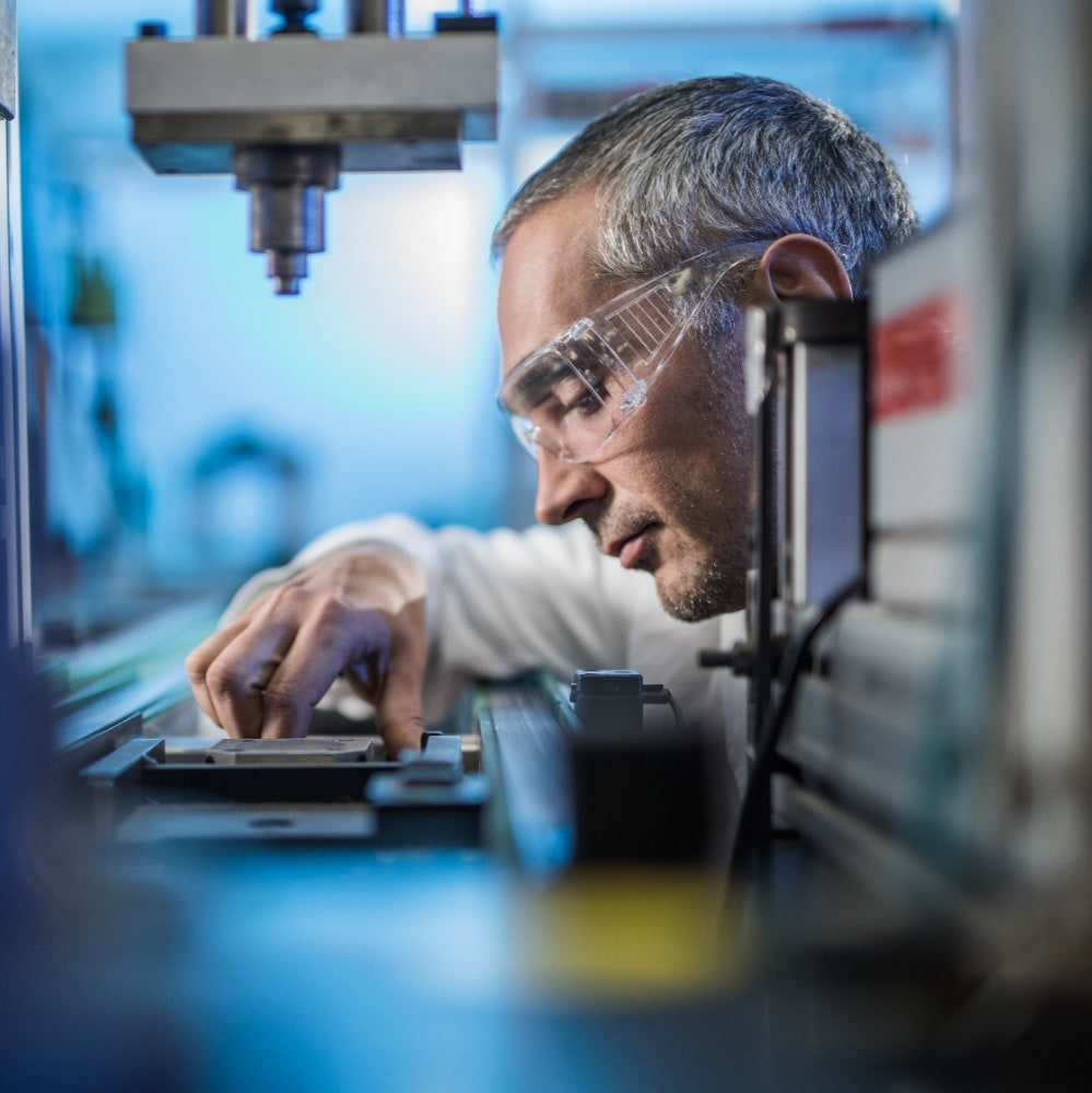 adult male technical engineer examining machine part on a factory production line in a factory