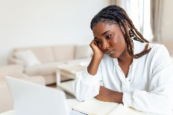 lady with head in hand looking at computer