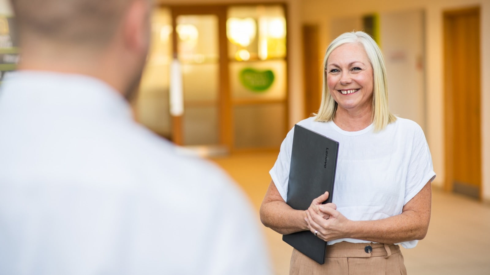 Leanne Chambers smiling and carrying a laptop