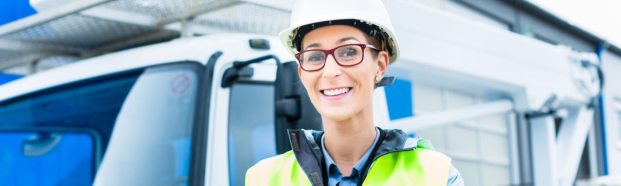 lady standing driver wearing red glasses hi vis jacket in front of crane truck lorry