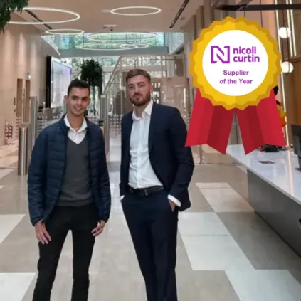 Two men in business attire standing in a shopping mall. 