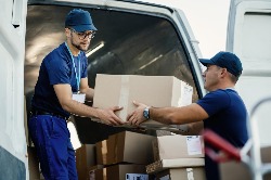 Two people moving boxes