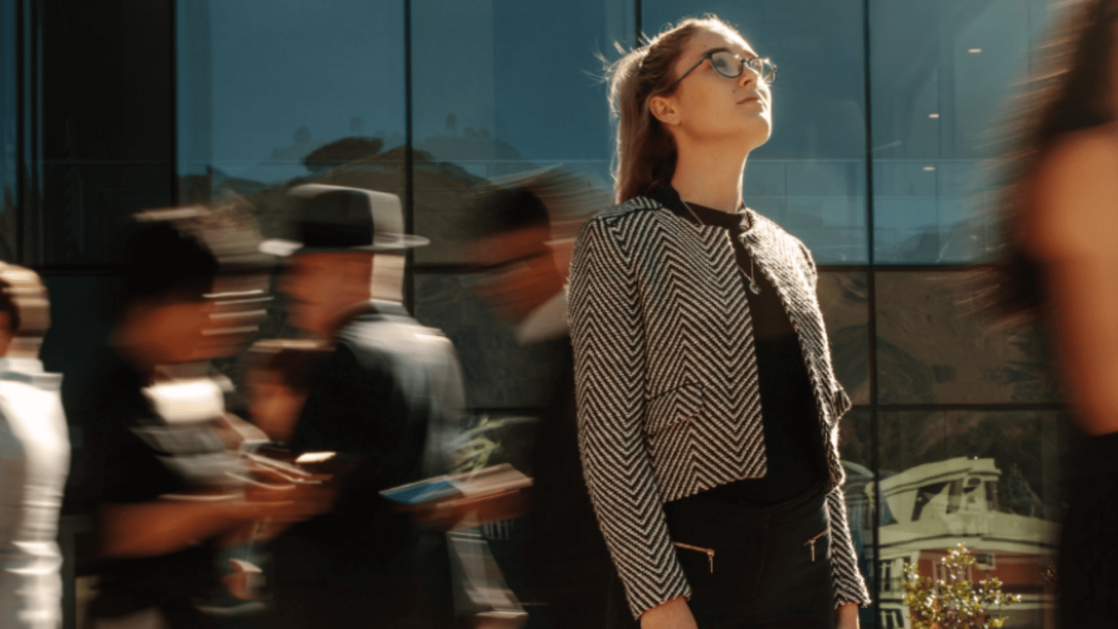 Woman on a busy street looking up at the sky