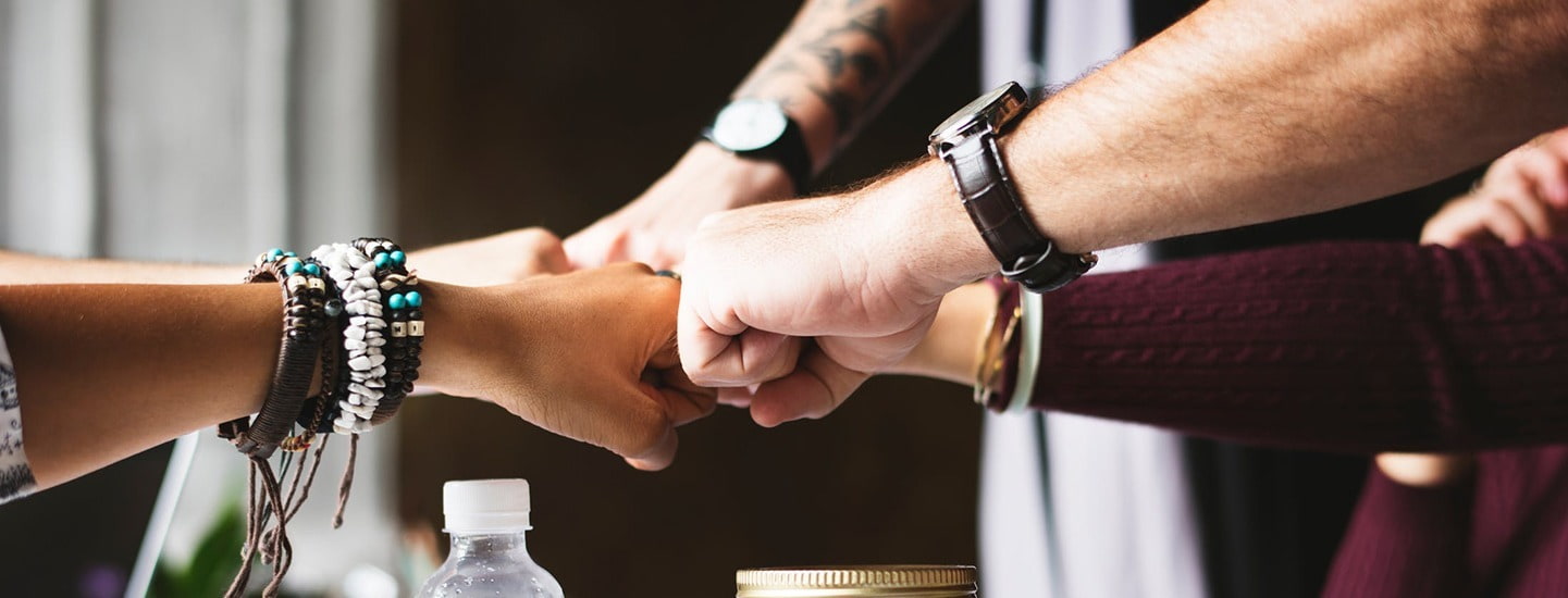 Close up of team putting their hands together 