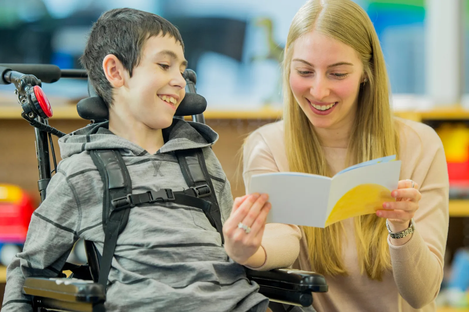 A woman talking to a boy in a wheelchair