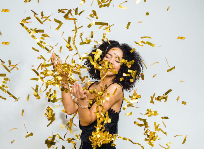 woman dancing in falling gold confetti
