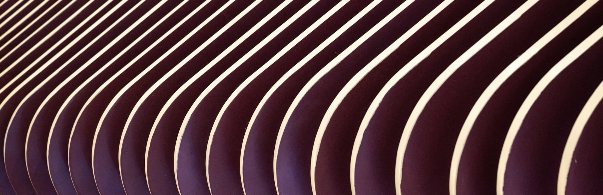 Close-up of a textured wall featuring smooth, flowing curved lines in a subtle color palette.