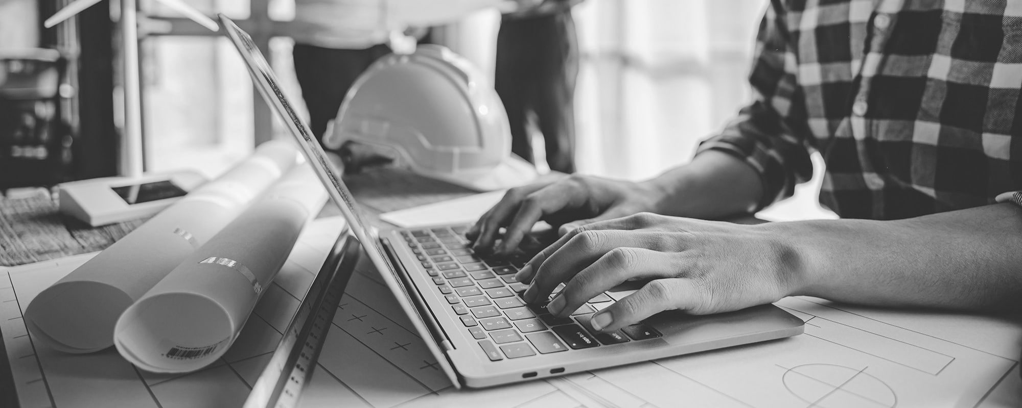 Construction worker typing on laptop