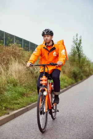 Just Eat delivery on the bike, wearing an orange working suit