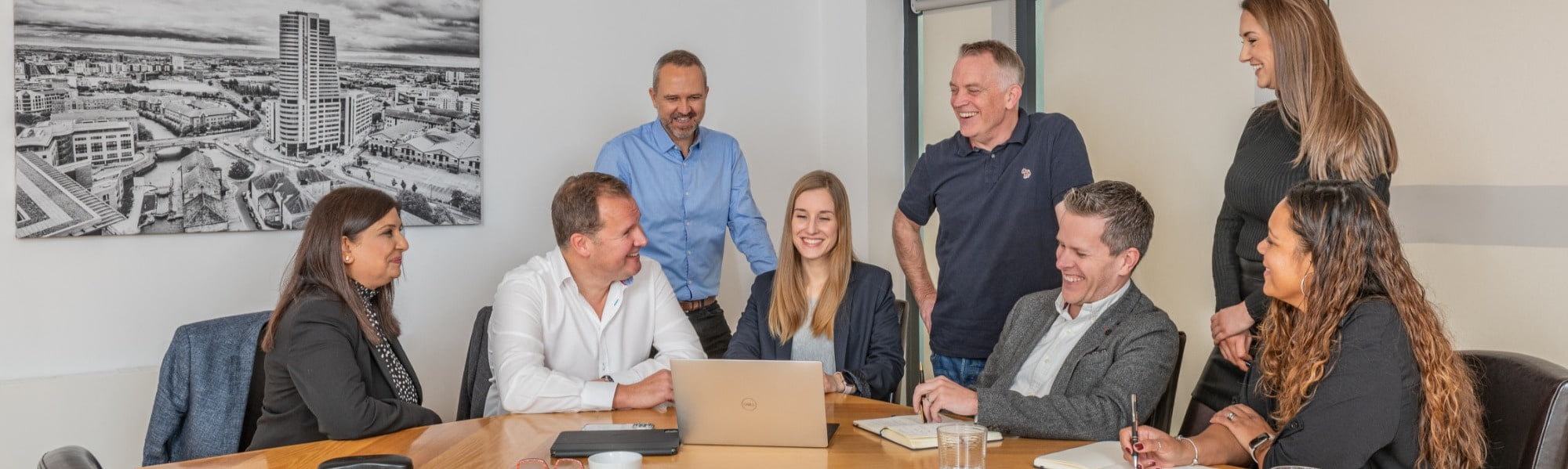 people sat around boardroom table with city backdrop