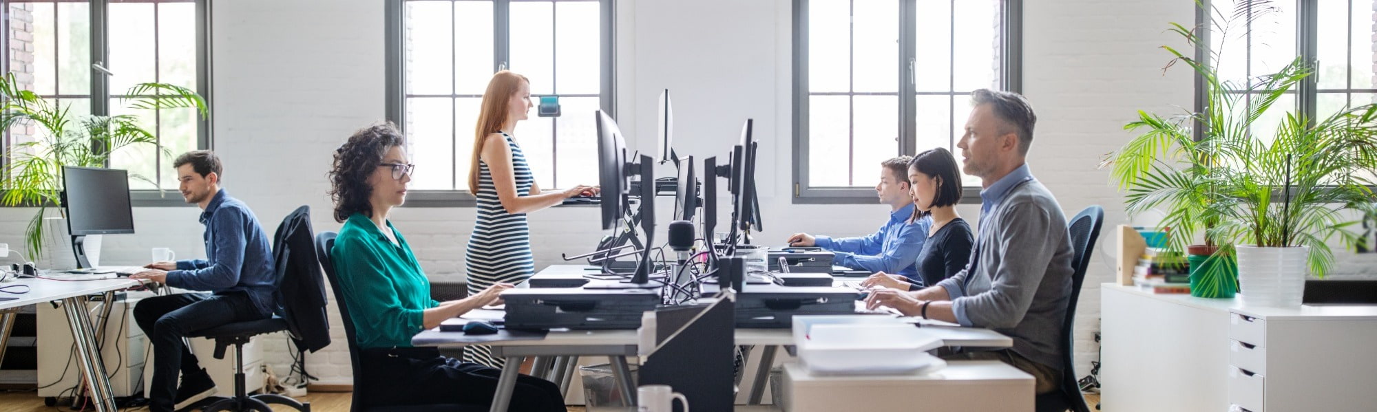 Business people at their desks in a busy, open plan office. Startup business people working at a modern office.